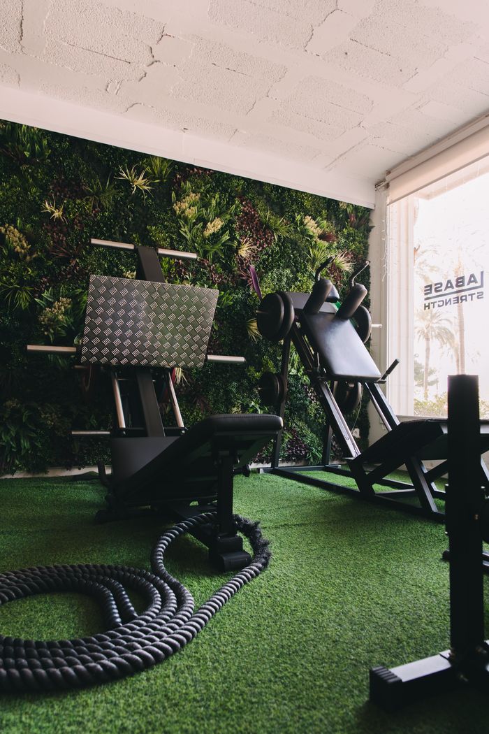 Sala de entrenamiento con pared vegetal y césped artificial