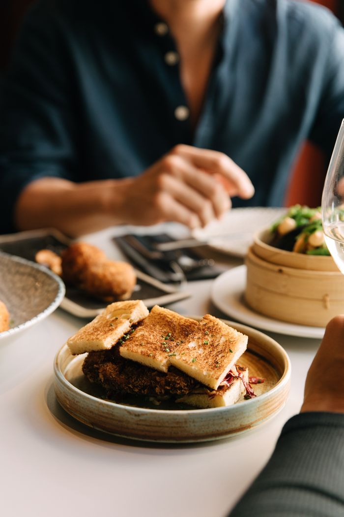 Comensal ante una mesa con pan de cristal y dim sum