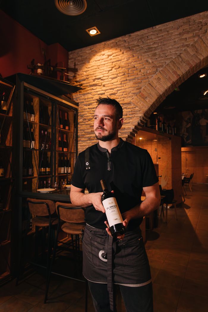 Sumiller con una botella de vino en la bodega de un restaurante